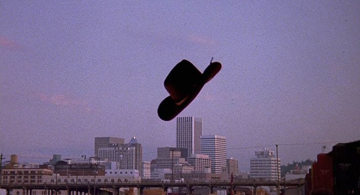 This may contain: a man flying through the air while riding a skateboard in front of a city skyline