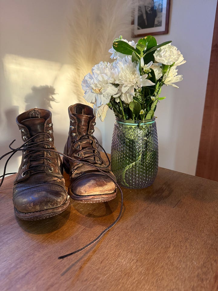 Andrea's boots on meg's bedside table, holding flowers like a vase