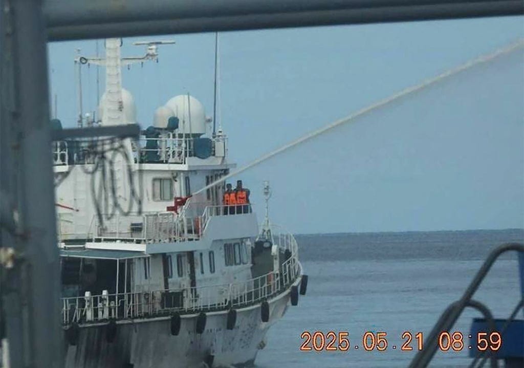 A China Coast Guard ship (left) deploys a water cannon against a Bureau of Fisheries and Aquatic Resources ship near Sandy Cay reef in the disputed South China Sea on Wednesday. Photo: Bureau of Fisheries and Aquatic Resources/Philippine Coast Guard/AFP