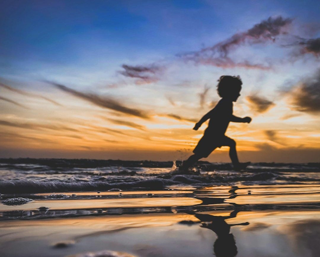 silhouette of woman running on beach during sunset