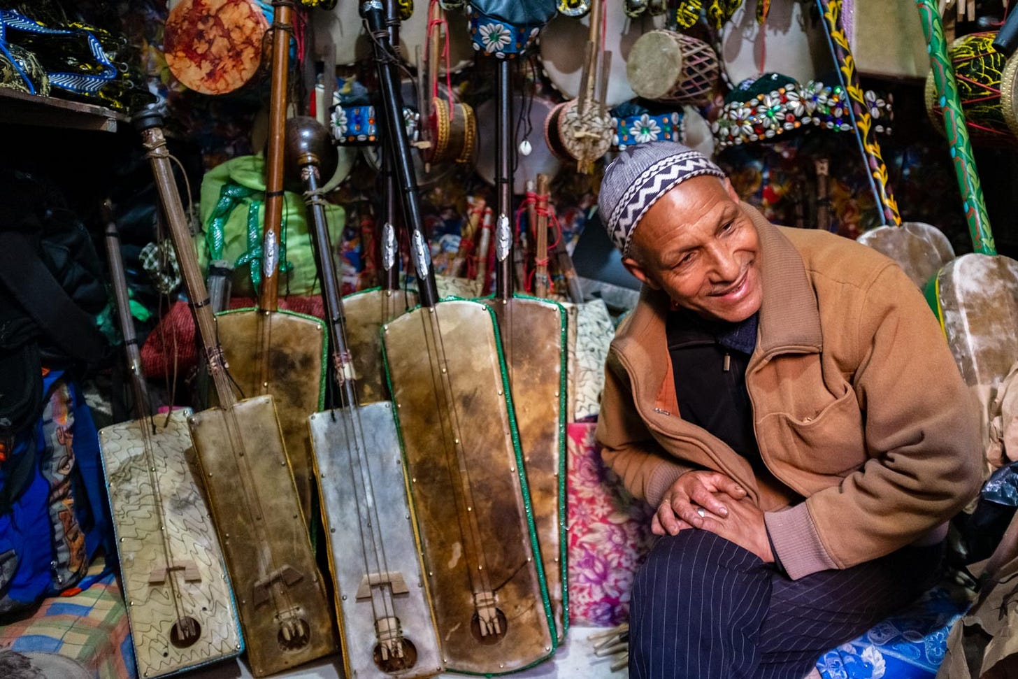 Mâalem Najeeb Soudani tussen zijn traditioneel vervaardigde guembri’s, krakebs en andere instrumenten in zijn muziekwinkeltje in Essaouira