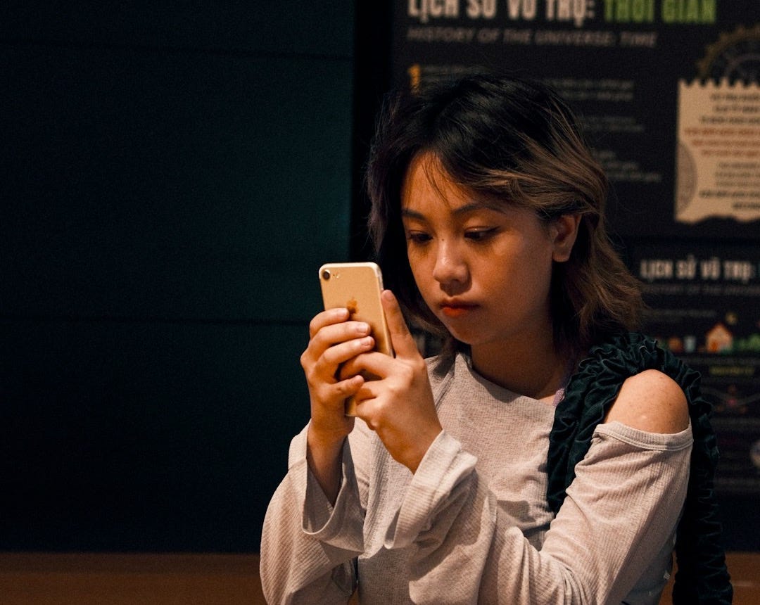 A woman is looking at her cell phone