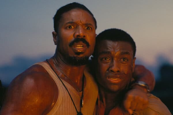 In an outdoor scene, two sweaty men clutch each other in fear. In an outdoor scene, two sweaty men clutch each other in fear.