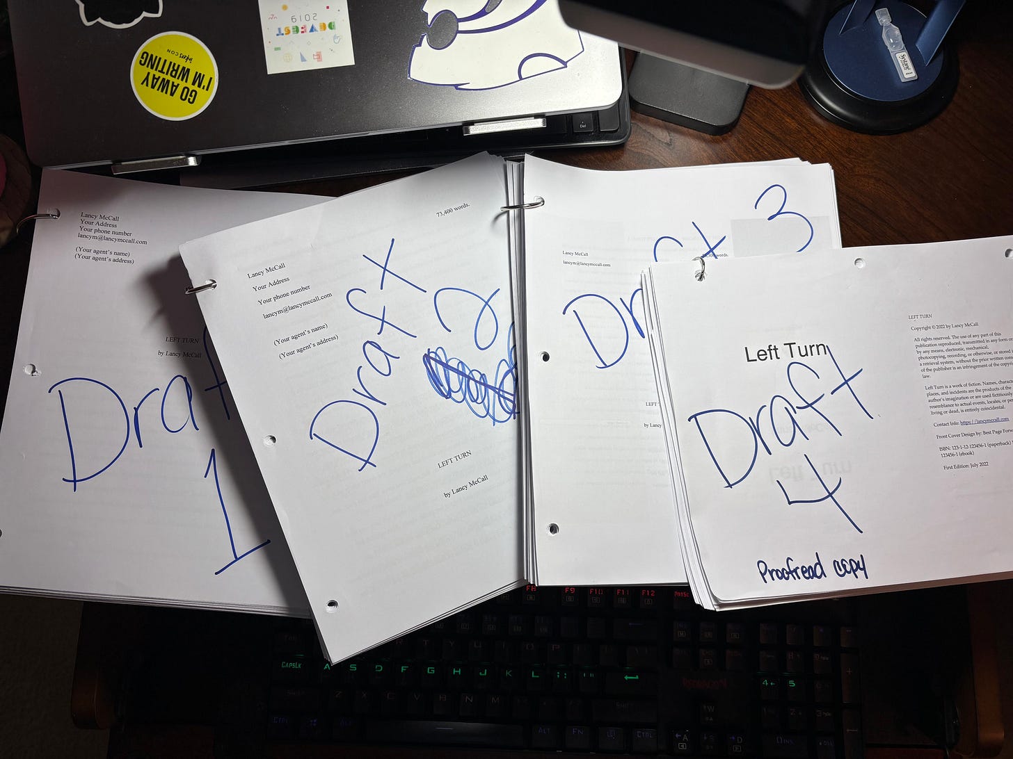 Image of four draft prints of Lancy's Left Turn manuscript spread out on a desk