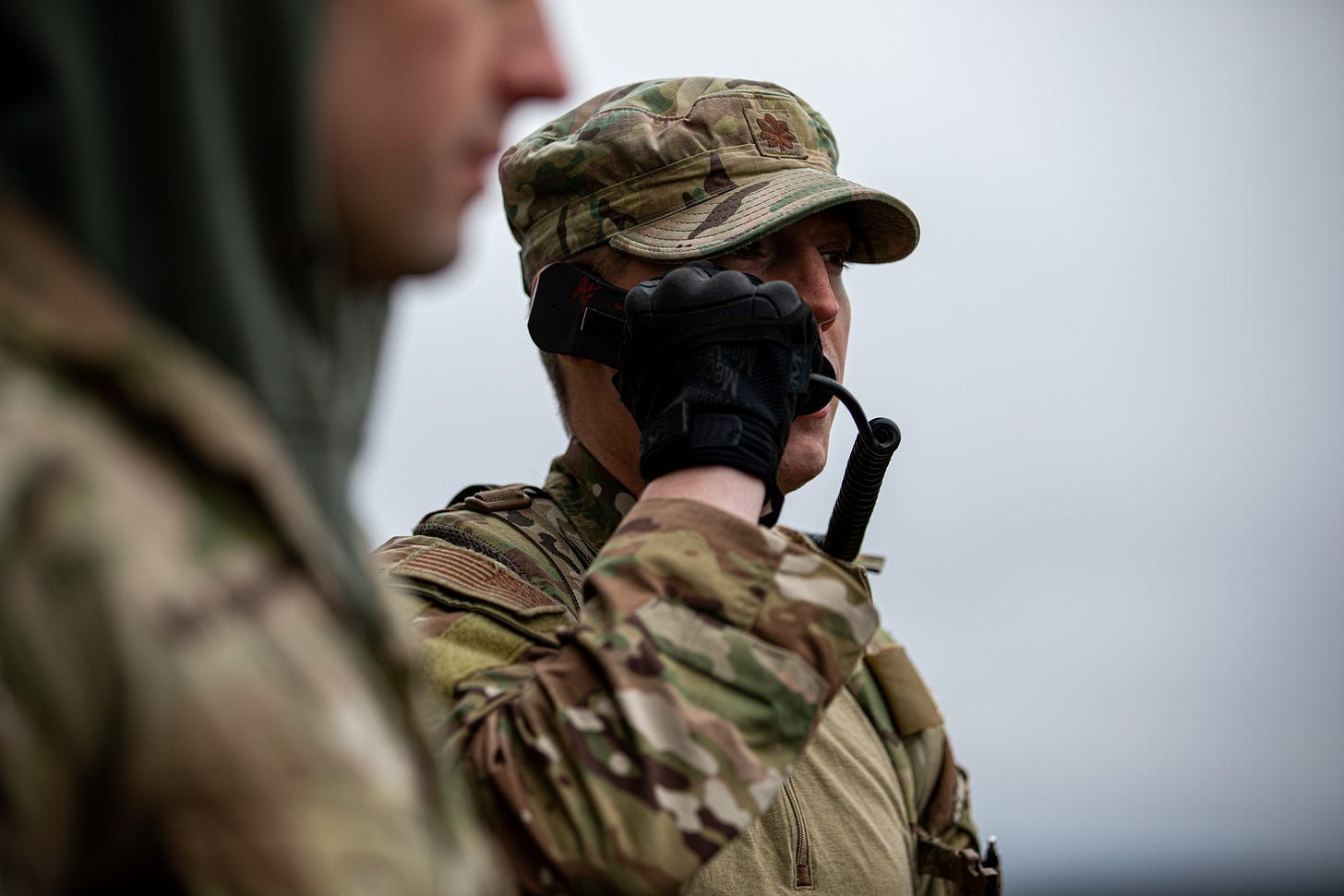 A U.S. Air Force officer speaks into a handheld radio while coordinating air support during Exercise Scarlet Dragon.