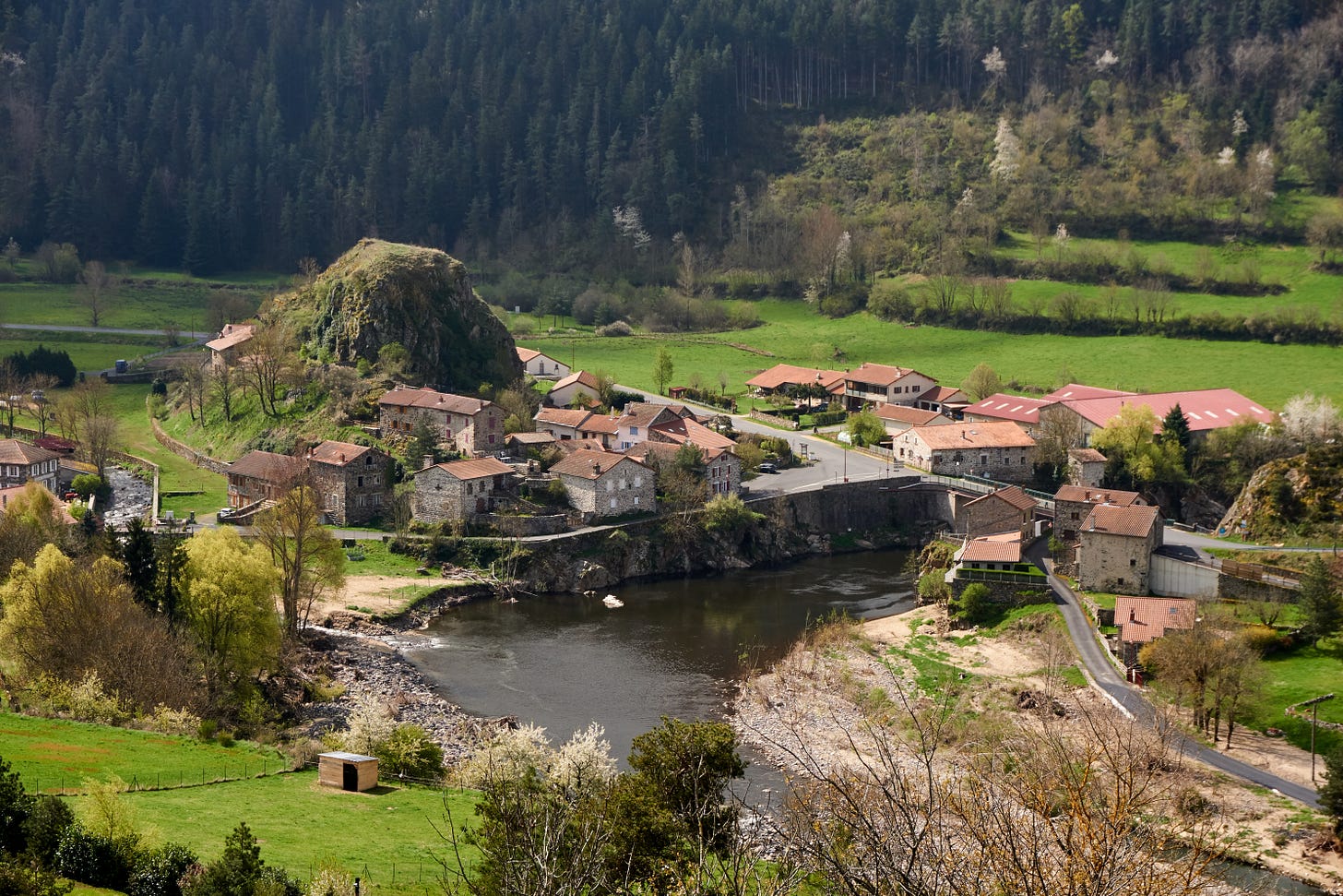 village by river with pointy hill in it (the village, not the river)