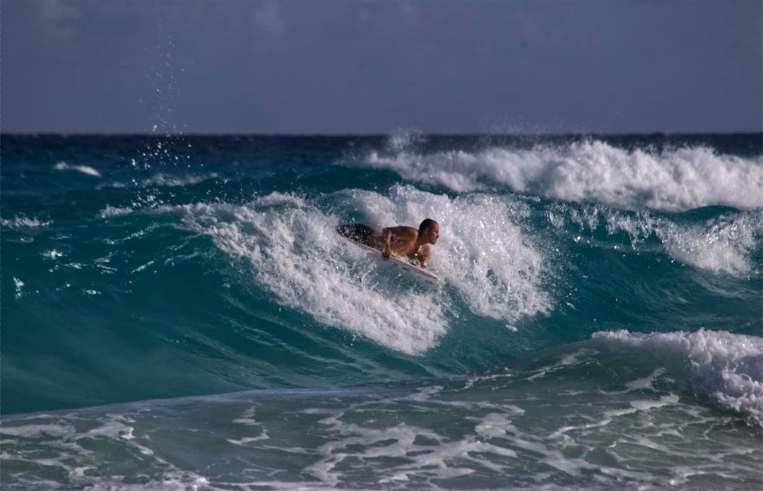 man surfing on sea waves during daytime
