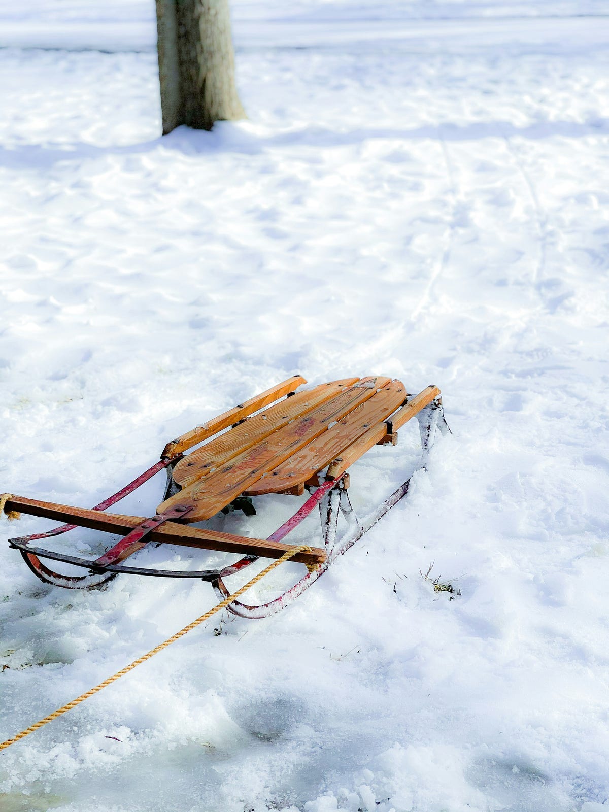 an old wooden sled with rope on fresh snow