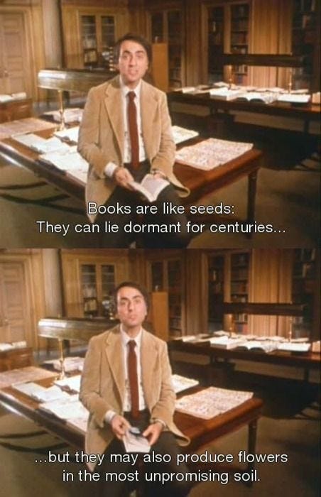 This may contain: a man in a suit and tie sitting at a desk with books on the table This may contain: a man in a suit and tie sitting at a desk with books on the table