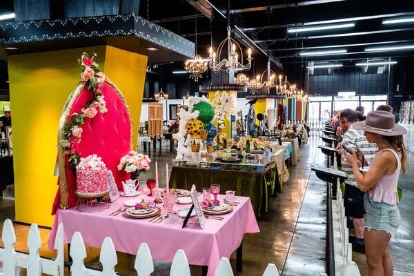 People admire a row of colorful dining tables.