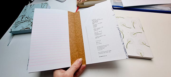 two handmade eco friendly and sustainable notebooks, hand bound and taped, one with a cover of dandelion clocks, one with stylised iamges of waves and the sea.