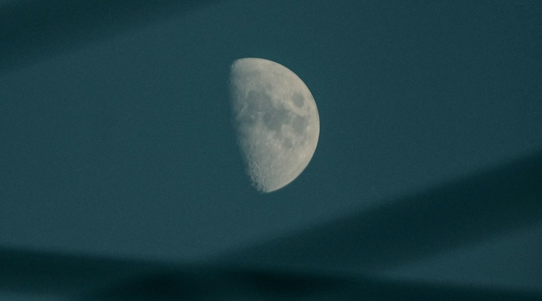 the moon is seen through the thin lines in the sky