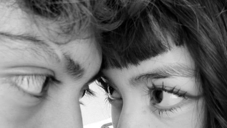 This may contain: two people are looking at each other with their eyes close to one another while they both look into the camera