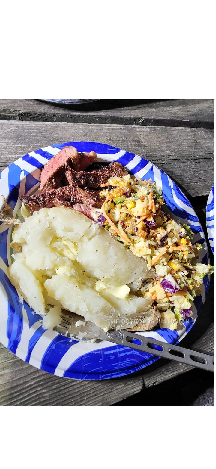 Two photos of hearty camp meals: one showing a pan of sizzling sausages with sautéed peppers and onions, and another showing a plate with a grilled steak, baked potato, and a fresh salad.