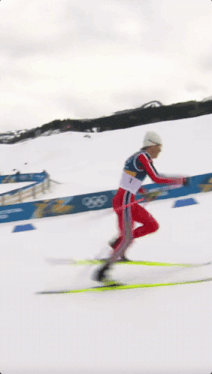 a man is skiing down a snow covered slope with a sign that says olympics in the background a man is skiing down a snow covered slope with a sign that says olympics in the background