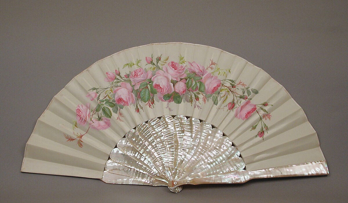 a white handheld fan with roses painted on the silk section and a mother of pearl handle
