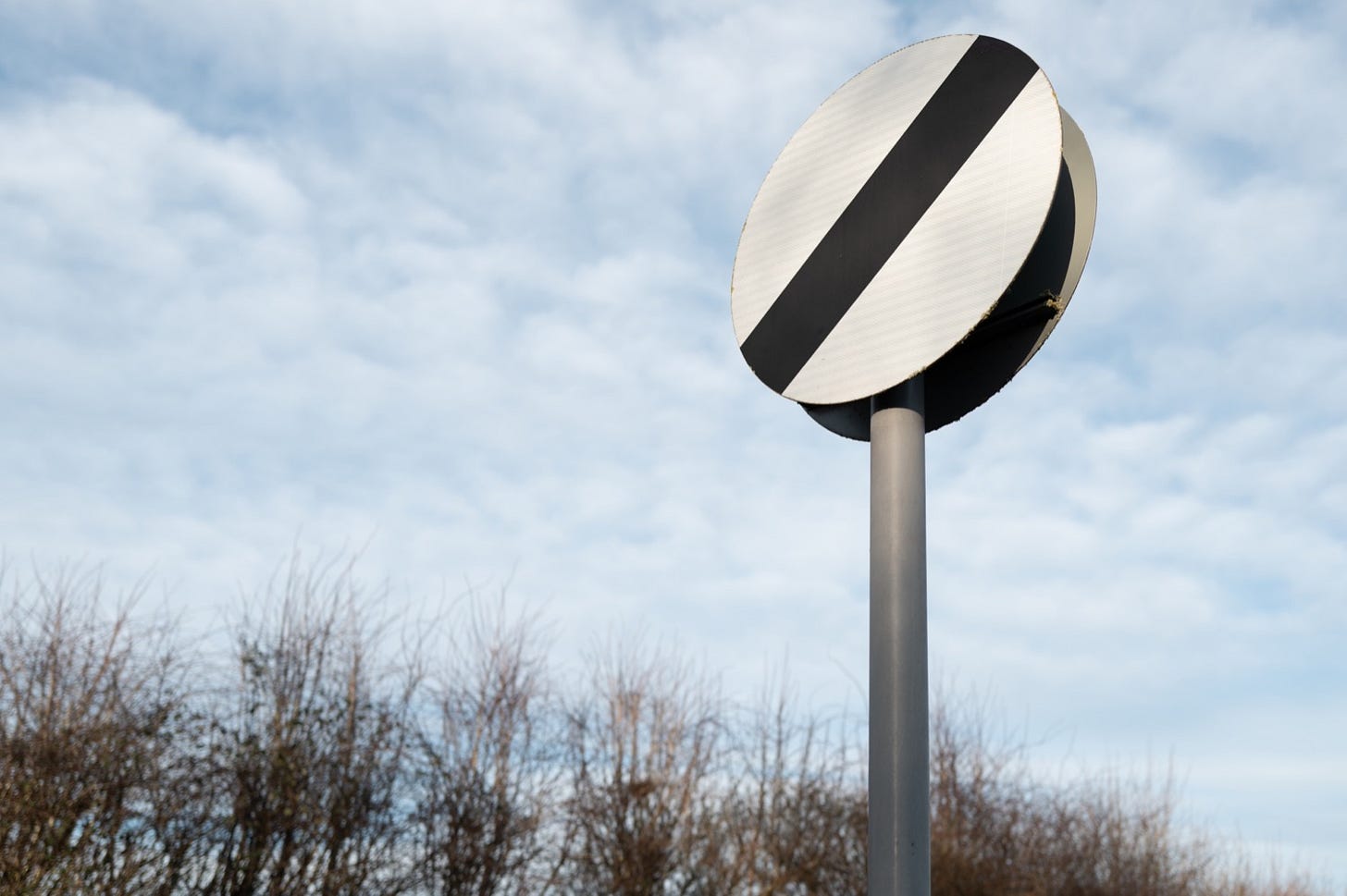 Huh? British national speed limit sign seen at the exit of a village in the east of England. (Nick Beer/shutterstock.com)
