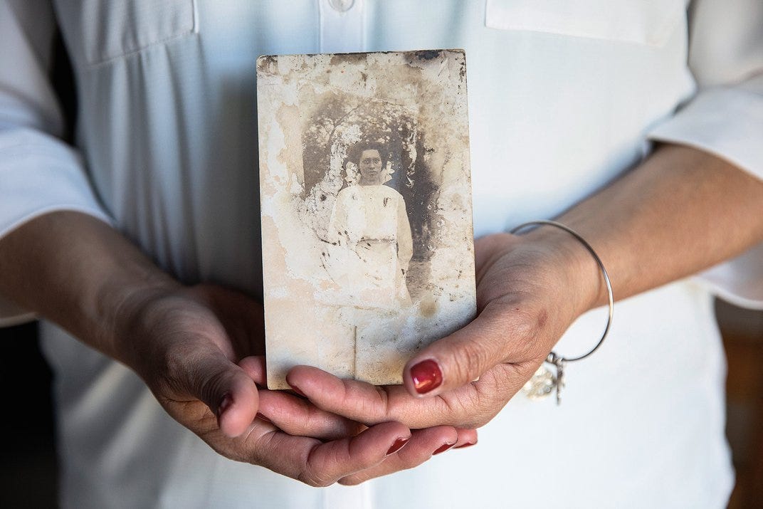 a women holds an old photograph a women holds an old photograph