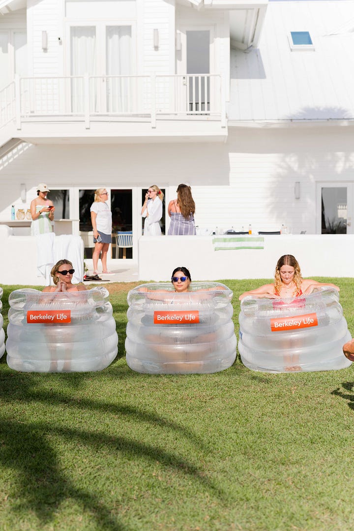 Three women in individual inflatable pools doing a cold plunge on the lawn; close up of one woman in purple sunglasses in the cold plunge.