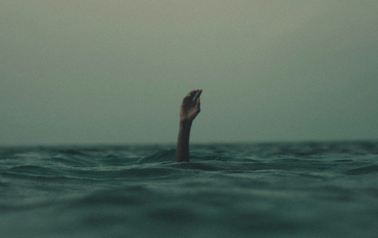 person with hand above water
