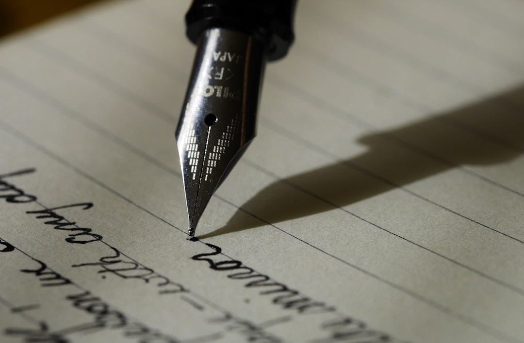 fountain pen on black lined paper