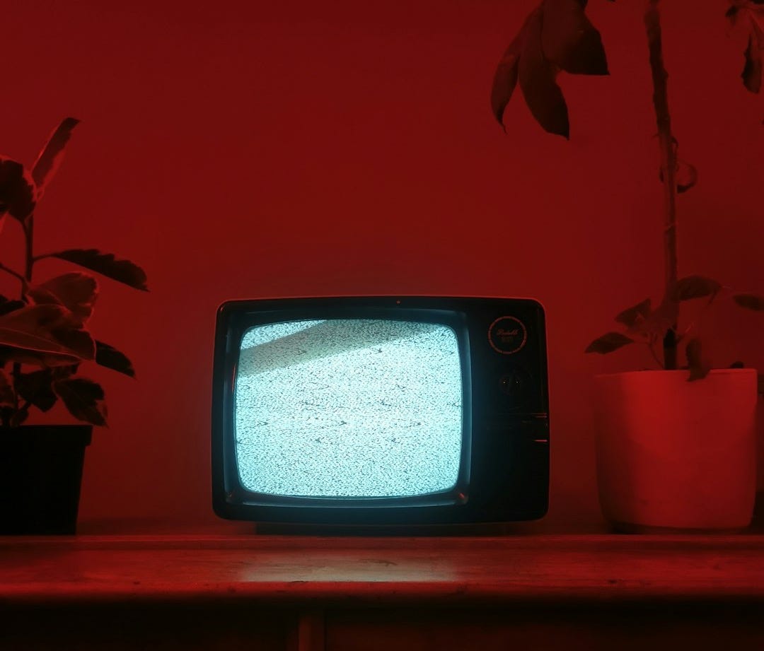 a small television sitting on top of a wooden dresser