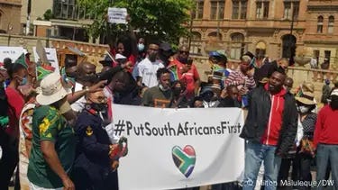 A group of South Africans is seen protesting against immigration outside the Gauteng High Court in Johannesburg, holding up a poster that reads "Put South Africans First" A group of South Africans is seen protesting against immigration outside the Gauteng High Court in Johannesburg, holding up a poster that reads "Put South Africans First"