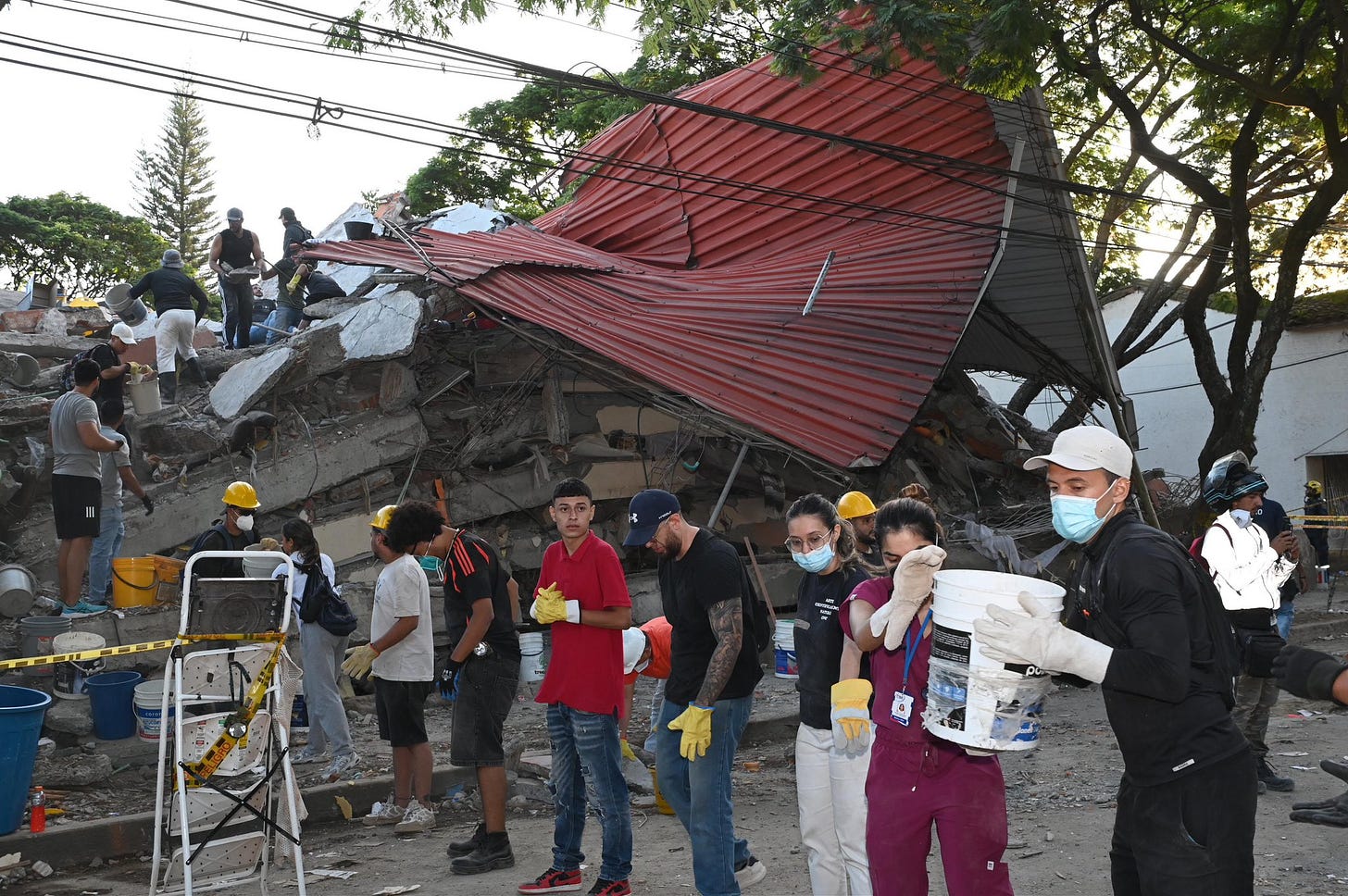First responders and civilian volunteers are sifting through the debris by hand with the help of buckets in Cali, Colombia, after a 7.4-magnitude earthquake struck the western part of the country on 10 August.