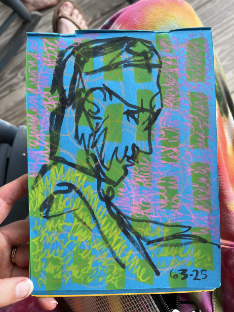 Three gestural black ink drawings on blue paper with textured colored writing.