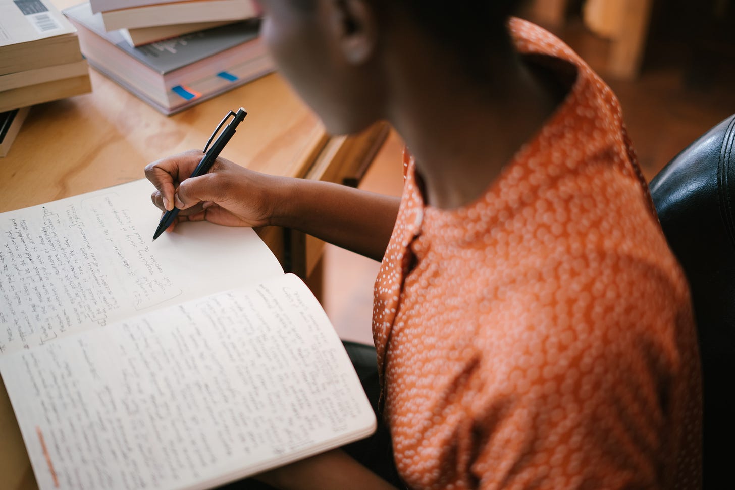 A woman studying and writing on a desk A woman studying and writing on a desk