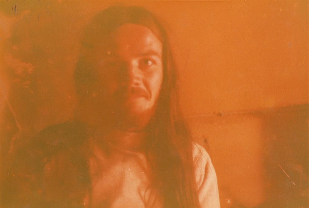 A person with long hair and mustache

Description automatically generated