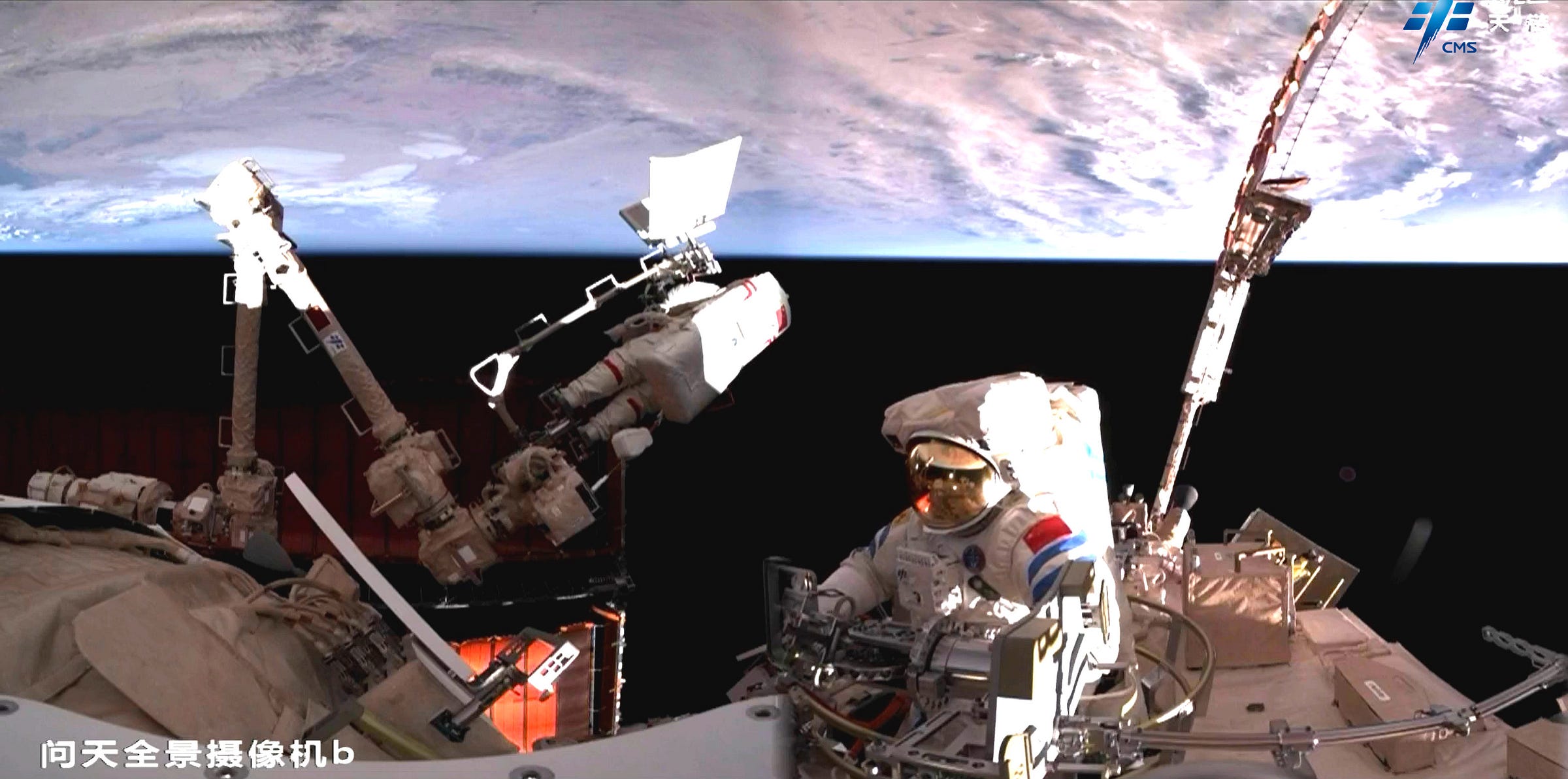 Song Lingdong emerging from the Wentian module while Cai Xuzhe is attached to Tiangong’s robotic arm. Song Lingdong emerging from the Wentian module while Cai Xuzhe is attached to Tiangong’s robotic arm.