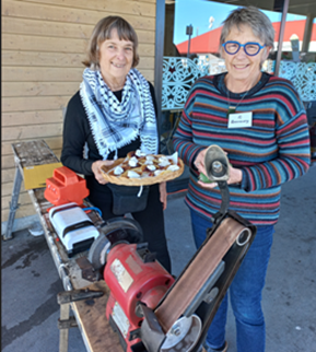 Joanna Santa Barbara offers pikelets at the knife sharpening station of the Motueka Repair Café.