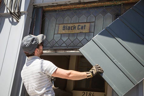 revealing the old hand painted sign at Black Cat Artspace