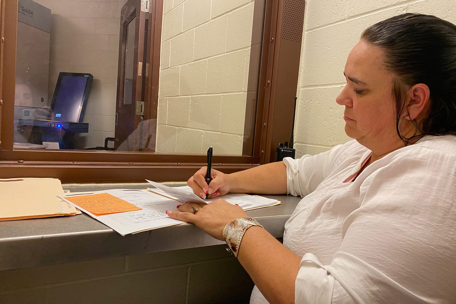 Cheryl Swapp, who is seated to the right of the frame, sits in a jail visitation room as she takes notes on standard size paper. Cheryl Swapp, who is seated to the right of the frame, sits in a jail visitation room as she takes notes on standard size paper.