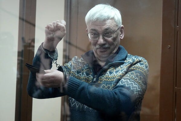 O co-presidente do Centro Memorial de Direitos Humanos, ganhador do Prêmio Nobel da Paz, Oleg Orlov, gesticula parado em uma gaiola de vidro depois de ser levado sob custódia no tribunal durante a sessão do tribunal para um novo julgamento sob a acusação de desacreditar repetidamente os militares russos, em Moscou, Rússia , na terça-feira, 27 de fevereiro de 2024. (AP Photo/Alexander Zemlianichenko)