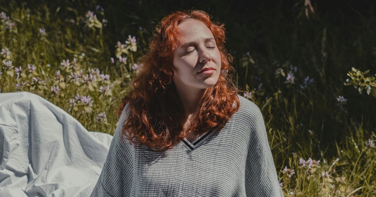 Woman sitting in nature contentedly Woman sitting in nature contentedly