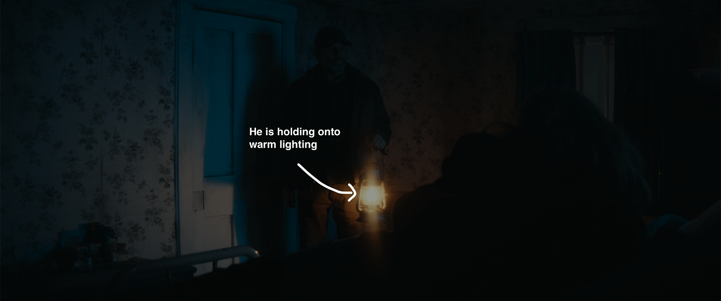 The man returning for Harmony Cobel, holding onto a lamp with warm lighting