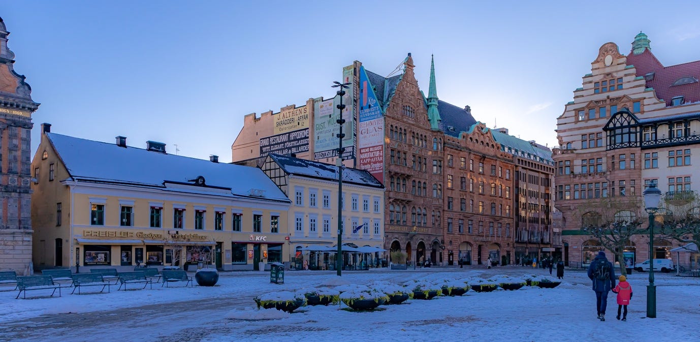 A snow covered street with buildings

AI-generated content may be incorrect.