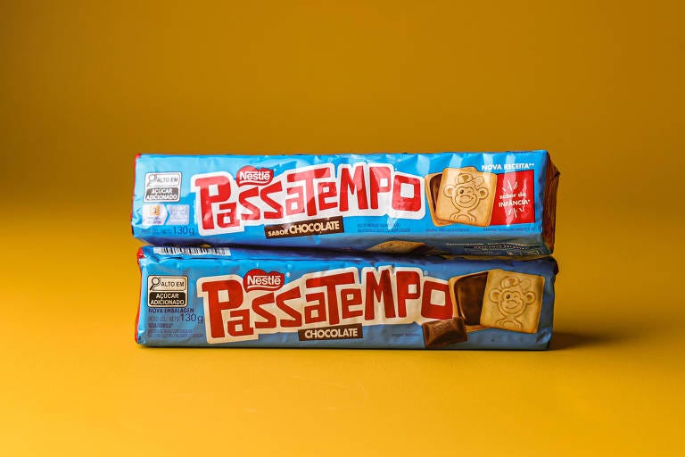 A imagem mostra dois pacotes de biscoitos Passatempo empilhados um sobre o outro. Os pacotes são de cor azul com o nome 'Passatempo' em destaque em letras vermelhas. O fundo da imagem é amarelo.