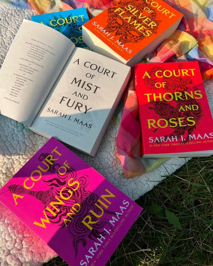 This may contain: four books laid out on a blanket in the grass