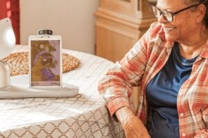 Woman interacting with a desktop robot.