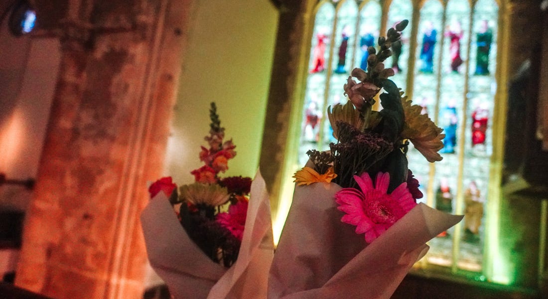 Two bouquets held up to a stained glass window Two bouquets held up to a stained glass window
