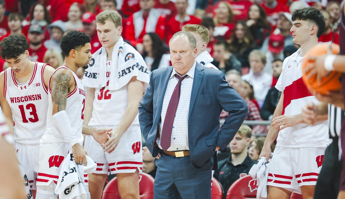Wisconsin Badgers head coach Greg Gard standing on the sideline by the bench during a game. Wisconsin Badgers head coach Greg Gard standing on the sideline by the bench during a game.