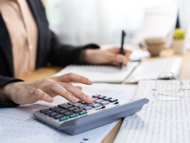 Persona haciendo cuentas en una calculadora (Foto vía Getty Images))
