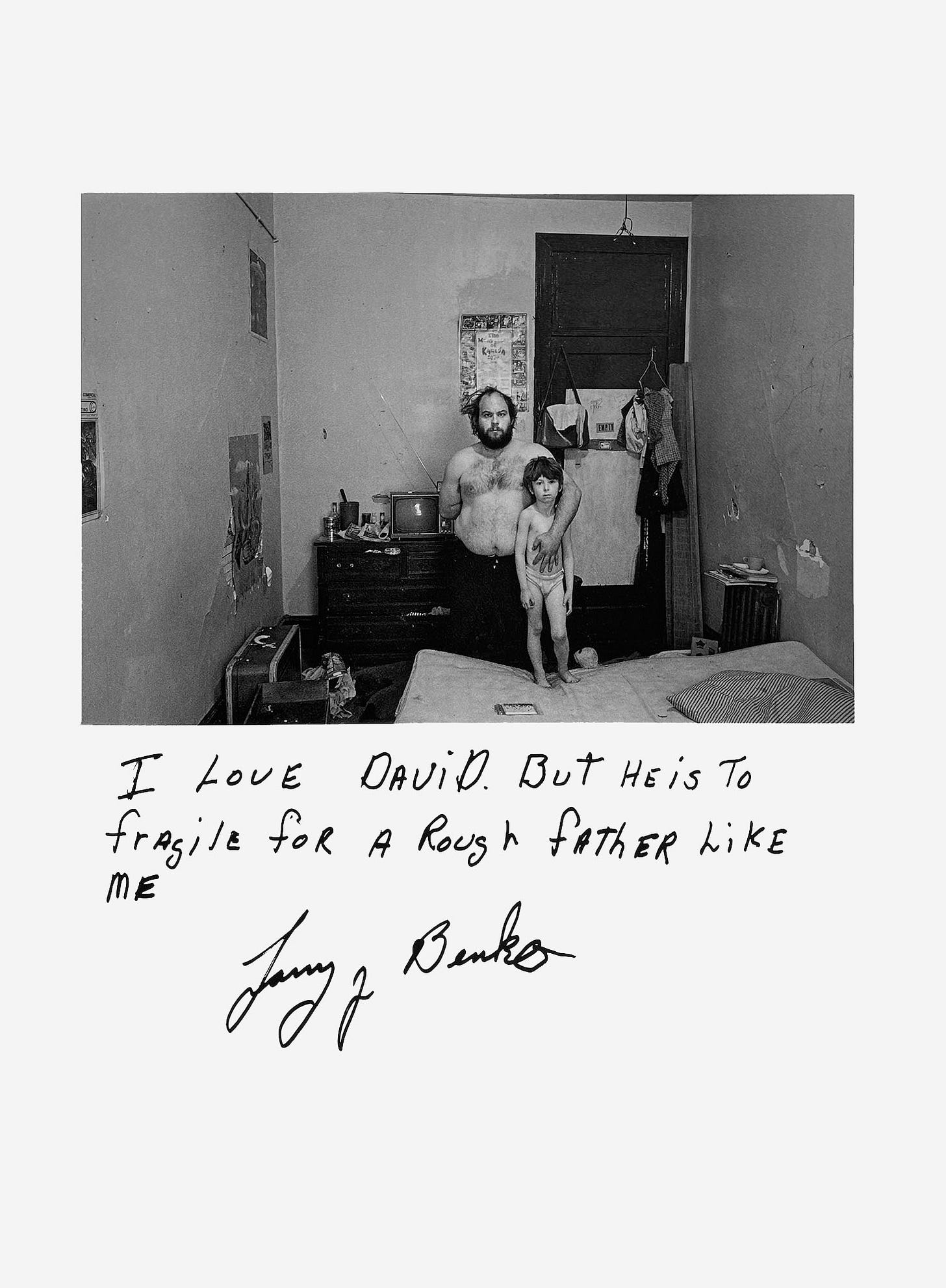In a room at a transient hotel, a shirtless man stands with his arm around a young child. A handwritten caption says, "I love David. But he is too fragile for a rough father like me. —Jerry Banks"