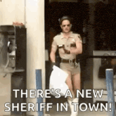 a man in a sheriff 's uniform is holding a bag of trash .
