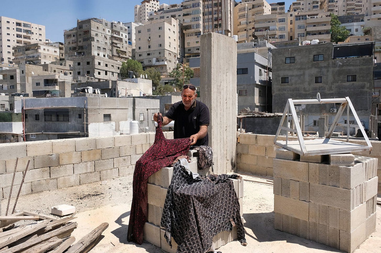 Qaid Jawda with the clothes his wife Zahia wore when she was shot to death last week. Qaid Jawda with the clothes his wife Zahia wore when she was shot to death last week.