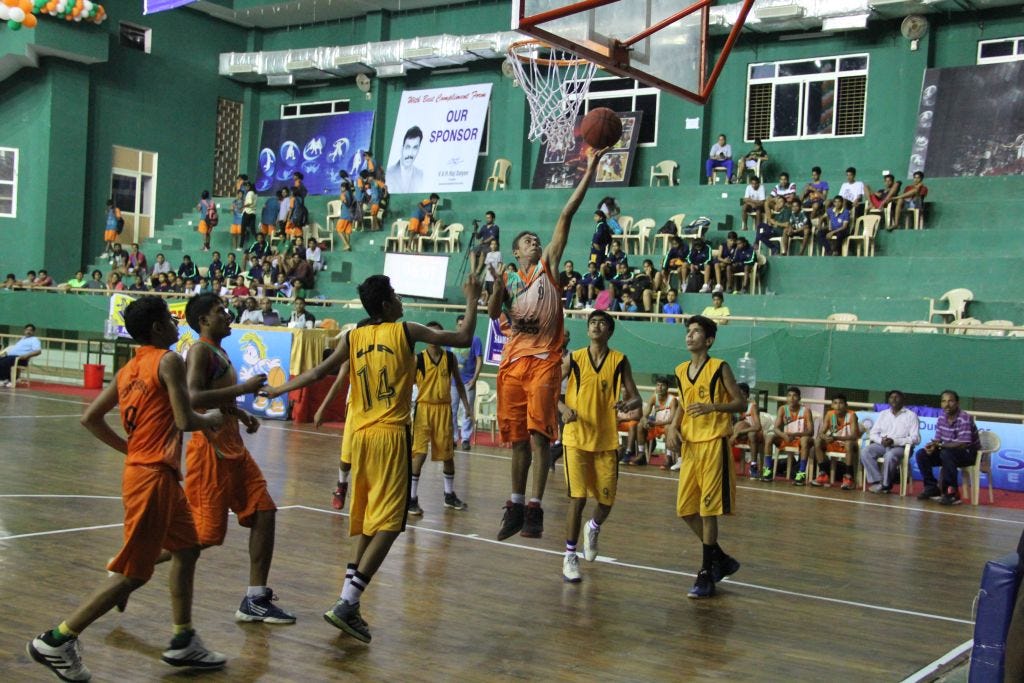 Chhattisgarh-player-in-orange-drives-in-for-the-layup-against-Uttar-Pradesh-in-yellow Chhattisgarh-player-in-orange-drives-in-for-the-layup-against-Uttar-Pradesh-in-yellow