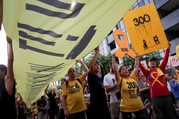Demonstrators at a rally show the number 300 on a shirt and a sign.